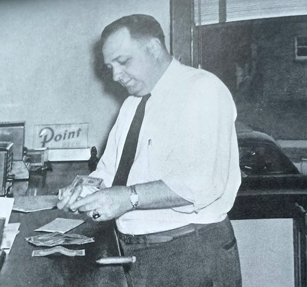 Felix “Phil” Shibilski, counting out money onto a countertop.