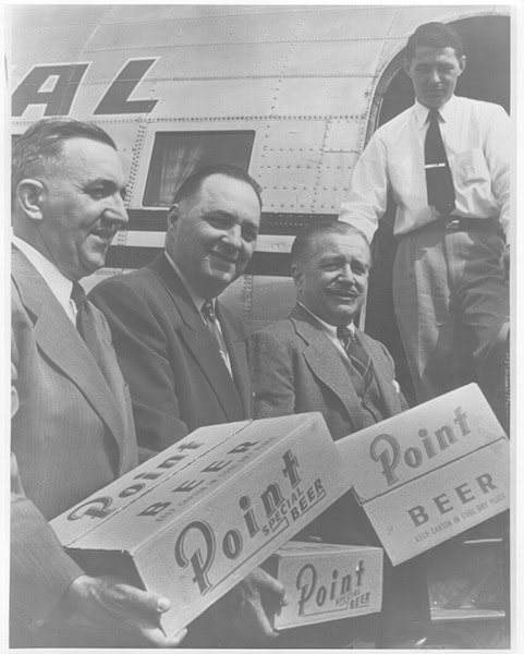 Phil Shibilski, Calvin Korfmann, and others help load a plane with Point Special cases for the Wisconsin exhibit in Washington, DC.